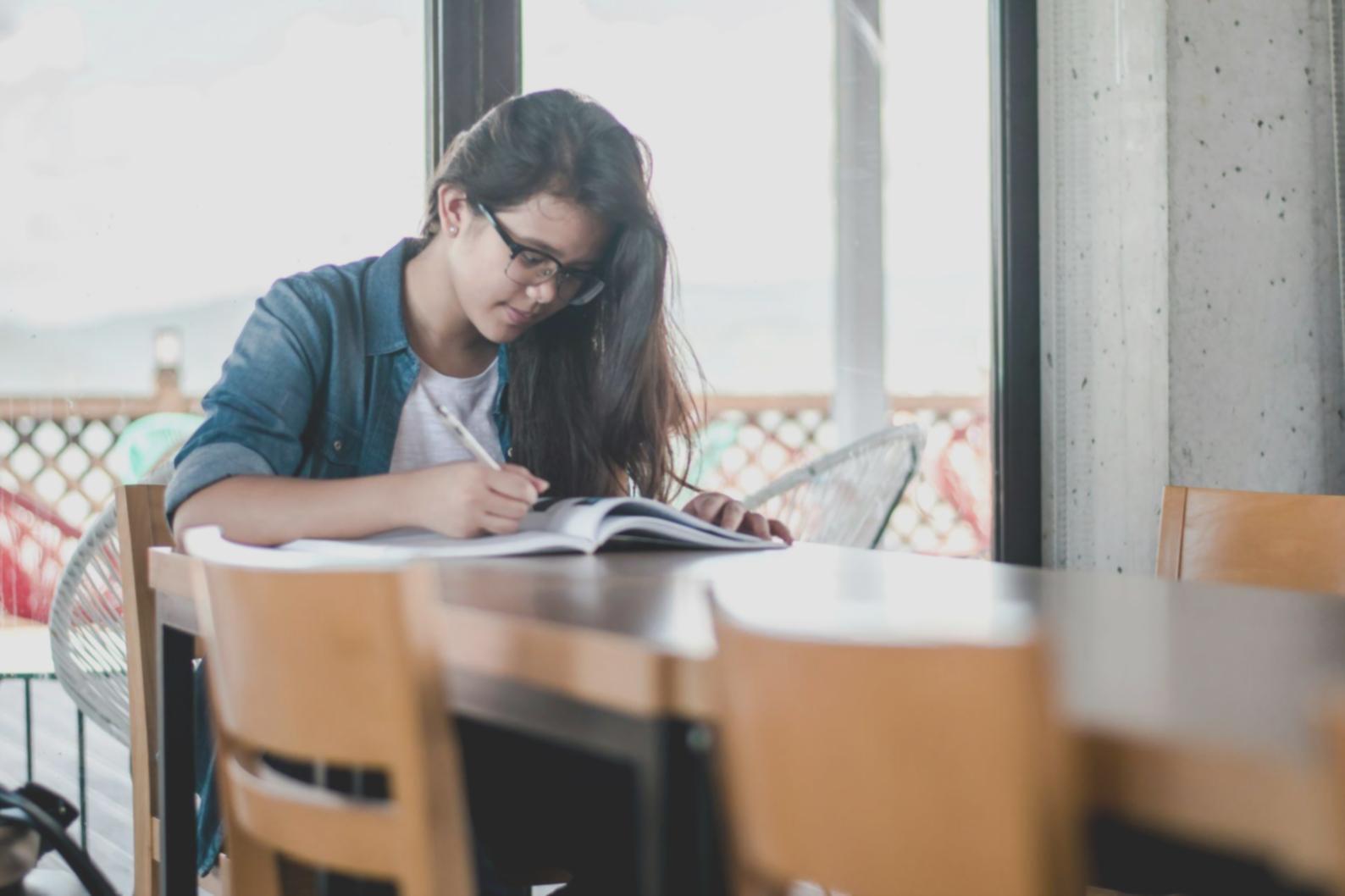 Estudiante revisando documentos financieros con calculadora